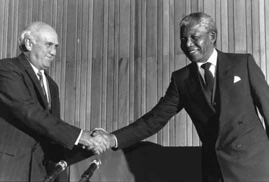 De Zuid-Afrikaanse president F. W. de Klerk schudt in april 1990 Nelson Mandela de hand