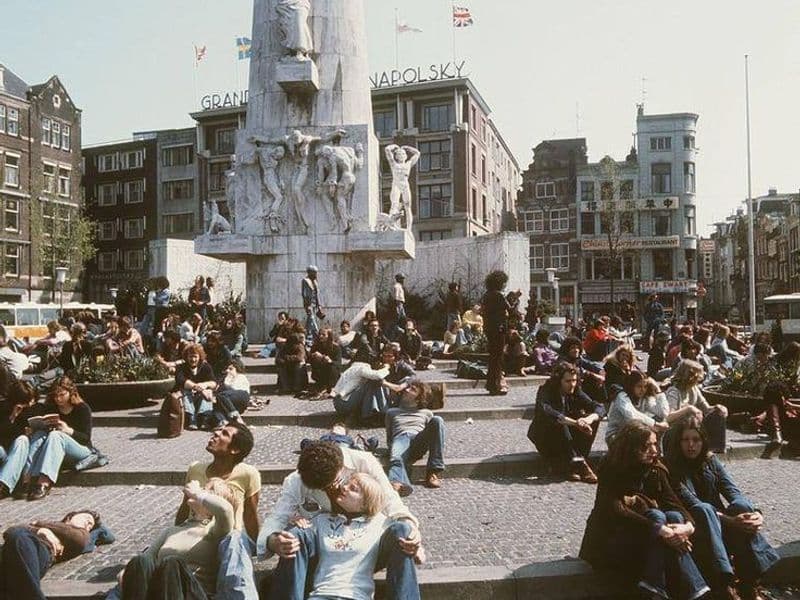Hippies bij monument op de Dam