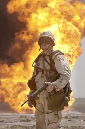 Een Amerikaanse soldaat bij een brandend olieveld tijdens de Irakoorlog van 2003