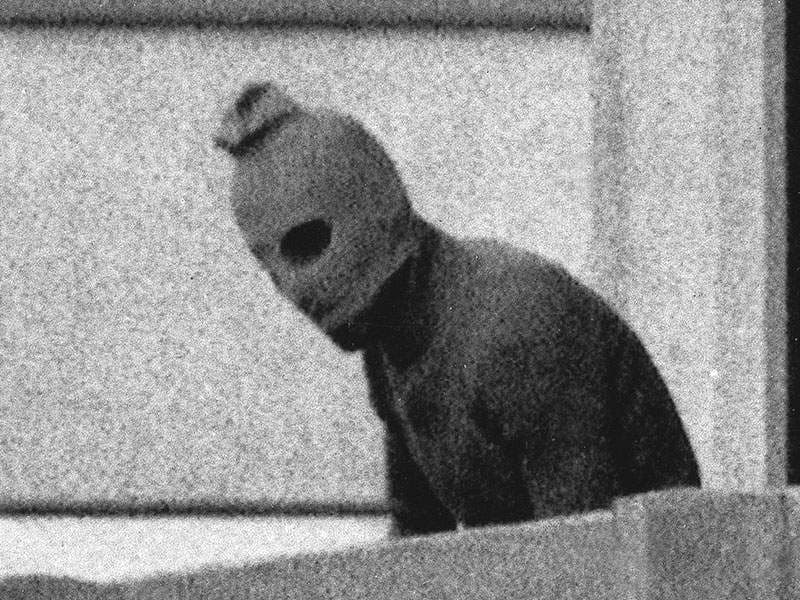 Een lid van de terroristenorganisatie Black September op het balkon van het Israëlische onderkomen